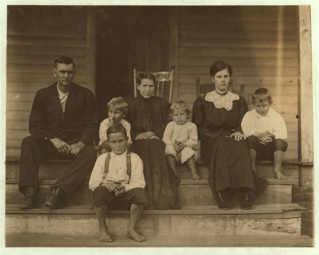 Johnie William Bumgarden (boy in front and part of his family). His birth record in the family bible says born May 7th, 190[2?] Just past his 10th birthday, is learning to doff. Got a regular job. 35 cents a day. Been at it a few weeks. Cannot write very well. Says he is 12 years old. Father said 5 of the family formerly worked in the mill making $28 a week. They take boarders which bring them $5 a week. A total of $33 a week. (Later the father said the record in the bible was put in wrong.) Rock Hill. S.C. Location: Rock Hill, South Carolina. 1912